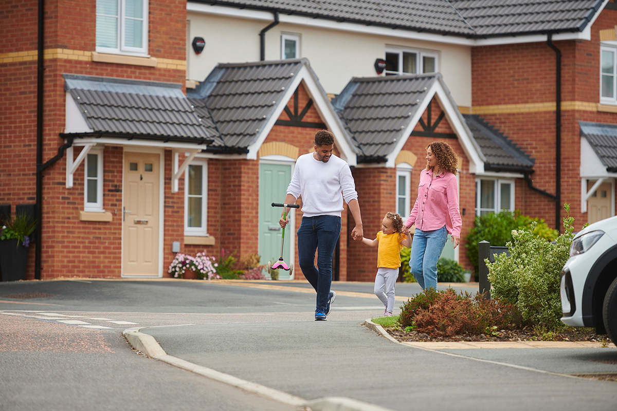 Family smiling walking through a housing development