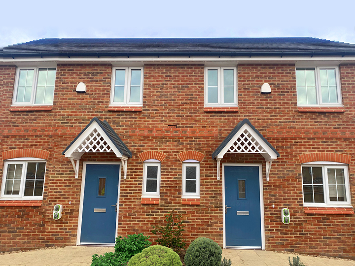 Two new-build terraced homes with navy blue front doors