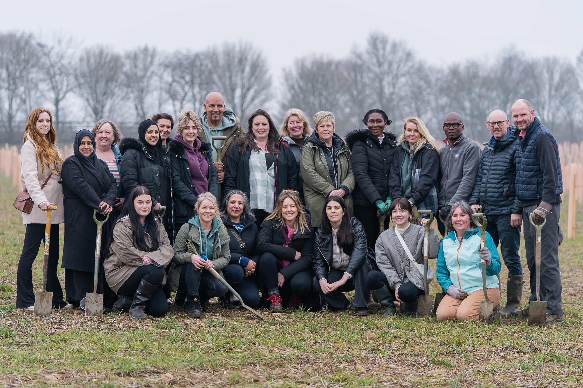 22 colleagues posed for a group photo at a tree planting event