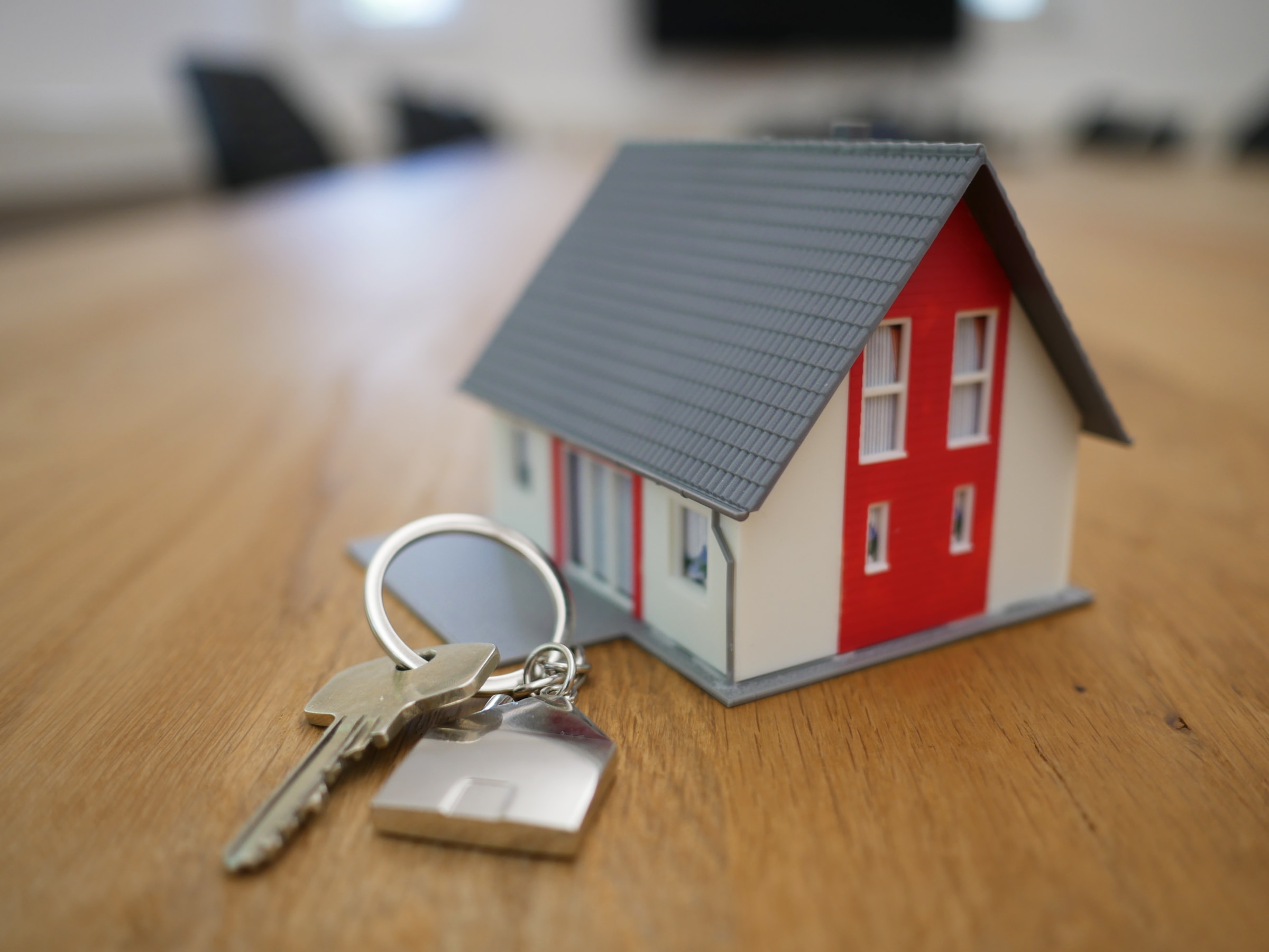Close-up of a keys on table, with a small metal house charm on the keyring